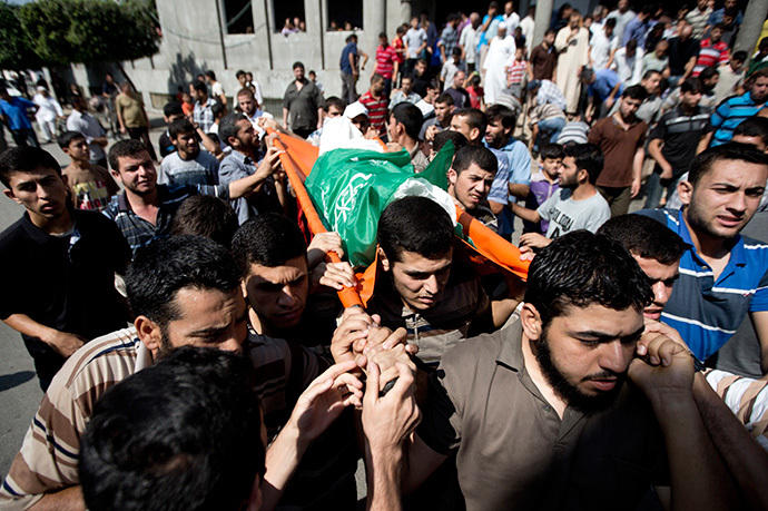 Palestinian mourners carry the body of Mahmud Abu al-Hosna, whose body was retreived from the rubble the day before, during his funeral in Jabalia in the northern Gaza Strip on July 27, 2014. (AFP Photo / Mahmud Hams)