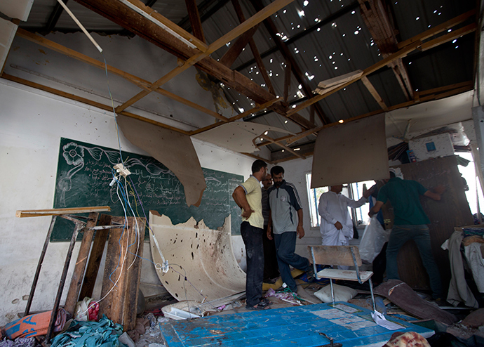 Palestinian men inspect the damage at a UN school at the Jabalia refugee camp in the northern Gaza Strip after the area was hit by Israeli shelling on July 30, 2014 (AFP Photo / Mahmud Hams)