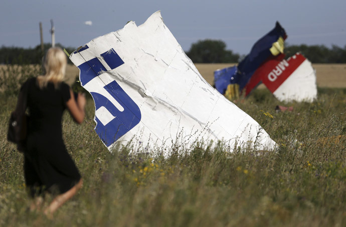 A woman walks past wreckage at the crash site of Malaysia Airlines Flight MH17 near the village of Hrabove (Grabovo), Donetsk region July 26, 2014. (Reuters/Sergei Karpukhin)