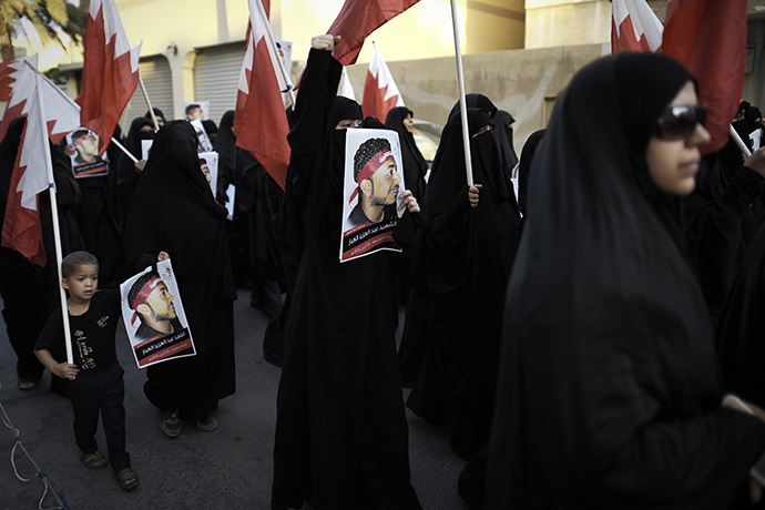 Bahraini women hold up posters bearing the portrait of Abdul Aziz al-Abbar during a protest condemning his death, on July 9, 2014 in the village of Sanabis, west of the capital Manama. (AFP Photo / Mohammed Al-Shaikh)