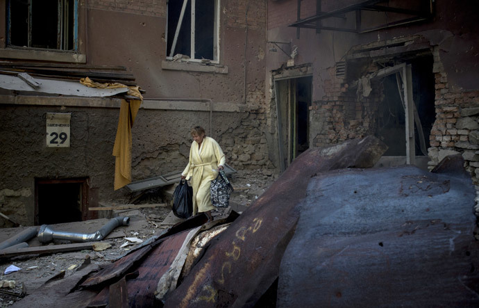 A woman is seen outside a residential building destroyed in an artillery attack by the Ukrainian army on Lugansk.(RIA Novosti / Valeriy Melnikov)