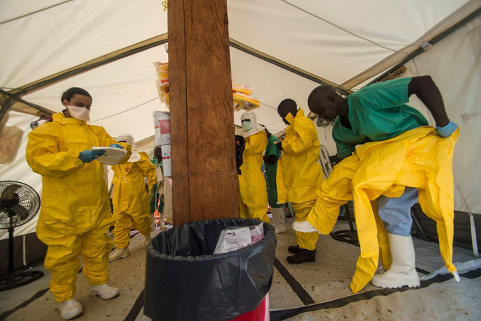Medical staff working with Medecins sans Frontieres (MSF) put on their protective gear before entering an isolation area at the MSF Ebola treatment centre in Kailahun July 20, 2014.(Reuters / Tommy Trenchard)