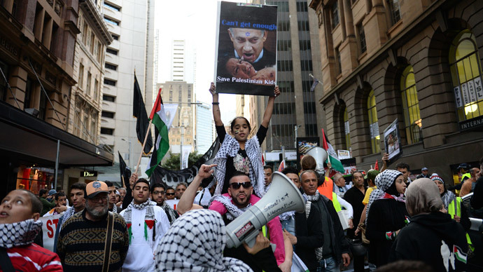 A girl (C) holds up a placard with an image of Israeli Prime Minister Benjamin Netanyahu during a rally in Sydney against Israel's military campaign in Gaza on August 3, 2014.(AFP Photo / Saeed Khan)