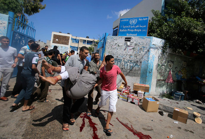 Palestinians carry a wounded man following what witnesses said was an Israeli air strike at a United Nations-run school, where displaced Palestinians take refuge, in Rafah in the southern Gaza Strip August 3, 2014.(Reuters / Ibraheem Abu Mustafa)