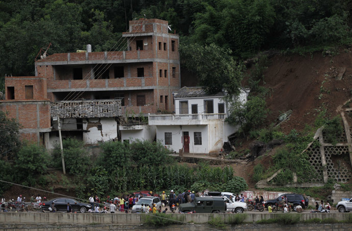 Residents gather near damaged houses following an earthquake in an area of Ludian county in Zhaotong in southwest China's Yunnan province on August 3, 2014. (AFP Photo / China Out )