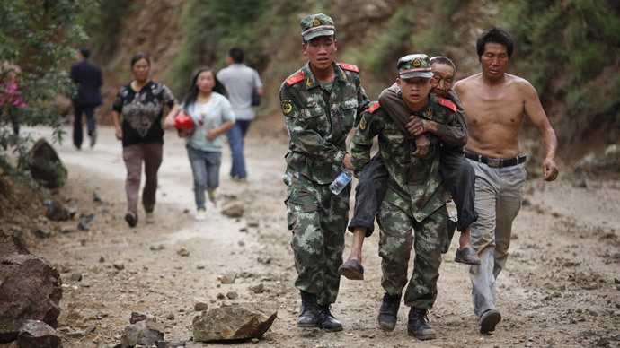 Chinese rescuers carry an injuried resident after an earthquake hit an area of Ludian county in Zhaotong in southwest China's Yunnan province on August 3, 2014.(AFP Photo / China out )