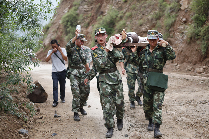 Chinese rescuers carry an injuried resident after an earthquake hit an area of Ludian county in Zhaotong in southwest China's Yunnan province on August 3, 2014 (AFP Photo)