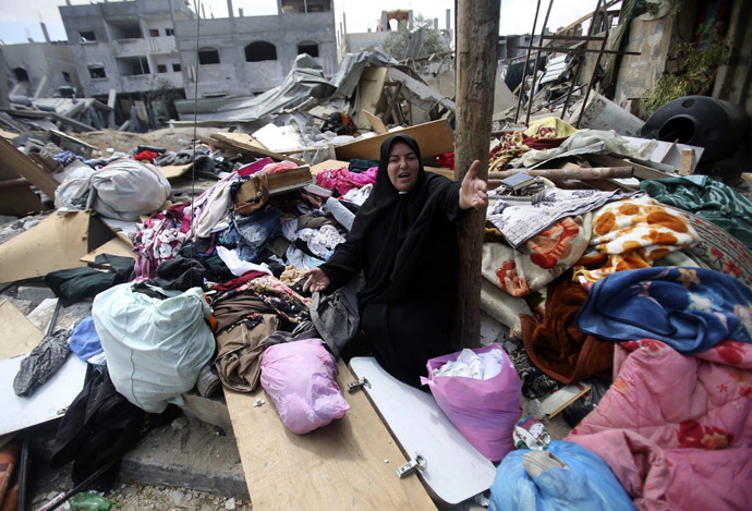 A Palestinian woman reacts as she collects her belongings from her house which witnesses said was destroyed in an Israeli air strike, in Rafah in the southern Gaza Strip August 4, 2014. (Reuters/Ibraheem Abu Mustafa)
