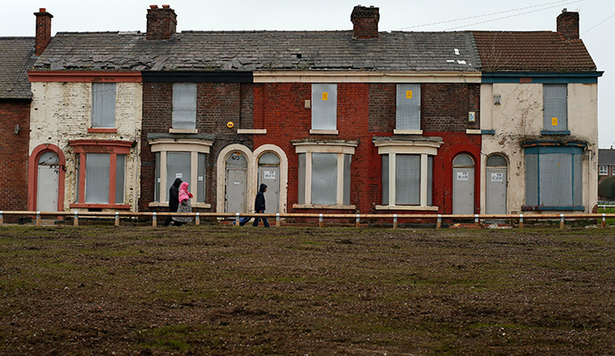 People walk past a row of boarded up terraced houses in the Kensington area of Liverpool, northern England (Reuters / Phil Noble)