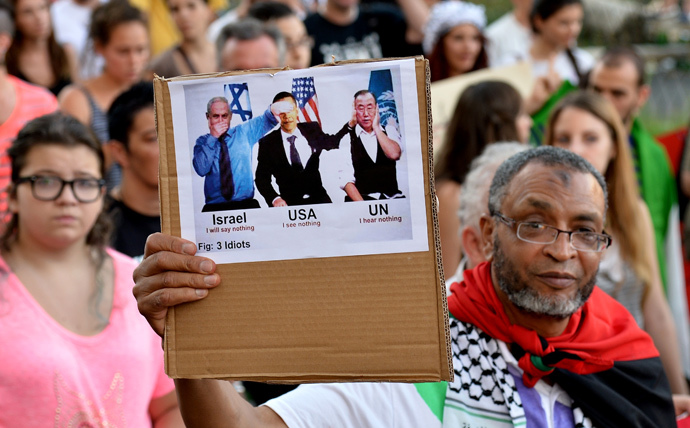 A man holds up a sign featuring (from L) Prime Minister of Israel Benjamin Netanyahu, US President Barack Obama and United Nations Secretary-General Ban Ki-moon during a demonstration in central Rome (AFP Photo / Tiziana Fabi) 