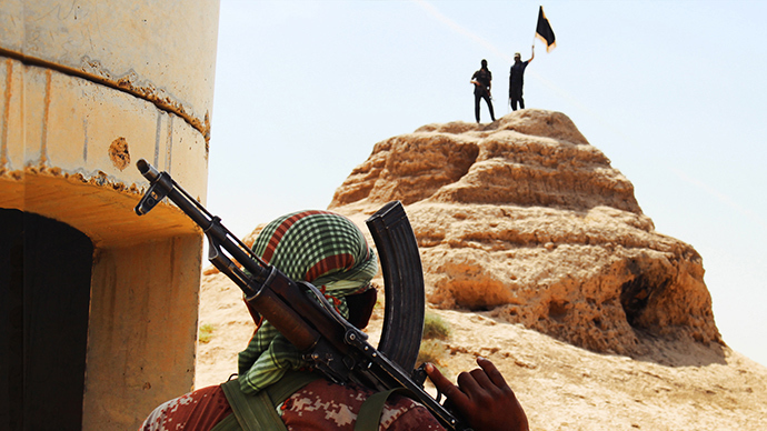 An image downloaded on June 11, 2014 from the jihadist website Welayat Salahuddin shows militants of the Islamic State of Iraq and the Levant (ISIL) waving the trademark Islamists flag after they allegedly seized an Iraqi army checkpoint in the northern Iraqi province of Salahuddin (AFP Photo / HO)