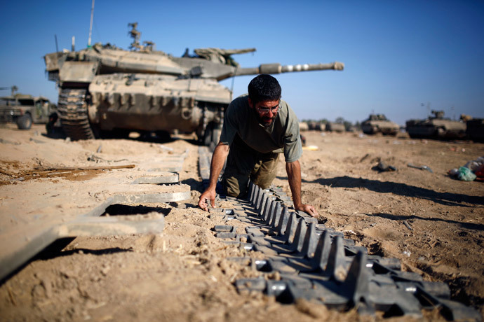 An Israeli reserve soldier checks a tank track near the border with Gaza August 6, 2014.(Reuters / Amir Cohen)