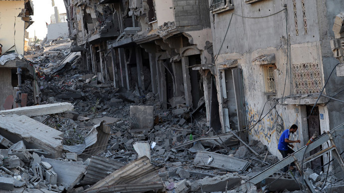 A palestinian man enters his partialy destroyed home in the devastated neighbourhood of Shejaiya in Gaza City on August 7, 2014.(AFP Photo / Roberto Schmidt)