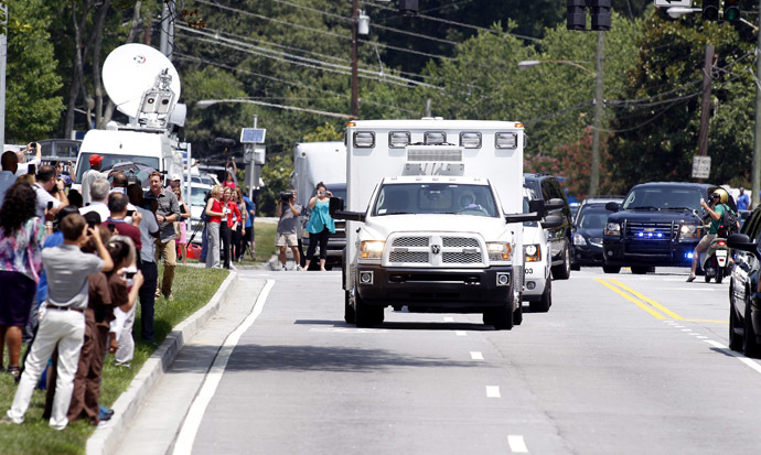 An ambulance carrying American missionary Nancy Writebol, 59, who is infected with Ebola in West Africa arrives past crowds of people taking pictures at Emory University Hospital in Atlanta, Georgia August 5, 2014. (Reuters/Tami Chappell)