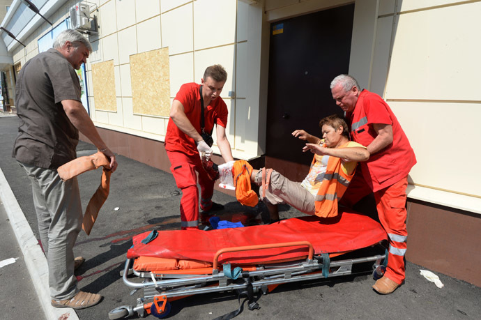 Medical workers help a woman wounded during the artillery shelling of Donetsk by Ukrainian forces. (RIA Novosti/Mikhail Voskresenskiy)