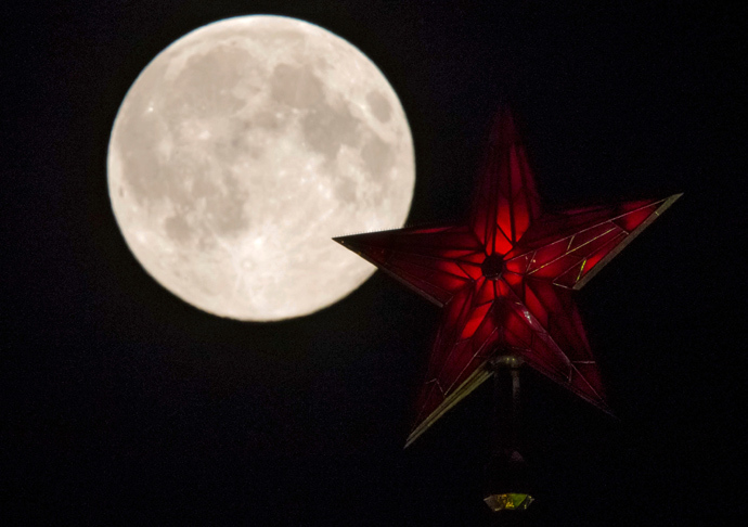 The supermoon rises over the stars of Moscow's Kremlin towers in Moscow August 10, 2014 (Reuters / Maxim Shemetov)