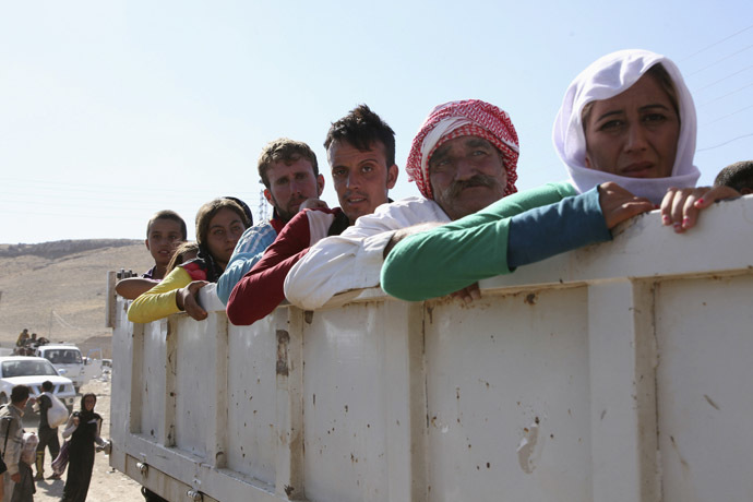 Displaced people from the minority Yazidi sect, fleeing the violence in the Iraqi town of Sinjar, re-enter Iraq from Syria at the Iraqi-Syrian border crossing in Fishkhabour, Dohuk Province, August 10, 2014. (Reuters/Ari Jalal)