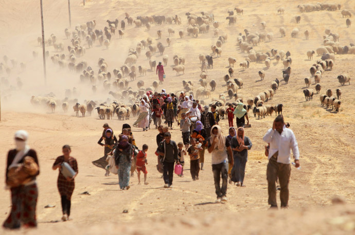 Displaced people from the minority Yazidi sect, fleeing violence from forces loyal to the Islamic State in Sinjar town, walk towards the Syrian border, on the outskirts of Sinjar mountain, near the Syrian border town of Elierbeh of Al-Hasakah Governorate August 10, 2014. (Reuters / Rodi Said) 