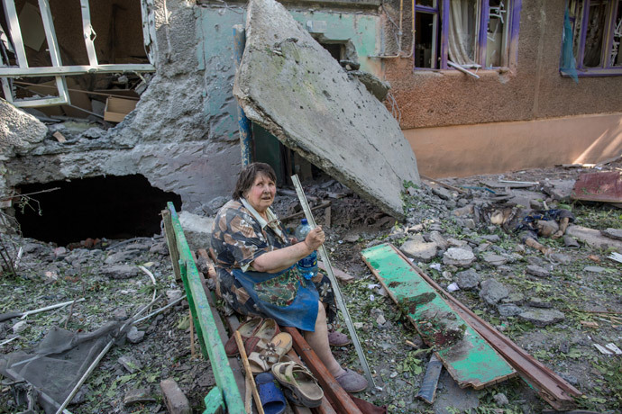 Resident of a building destroyed by an artillery bombardment of Slavyansk by Ukrainian servicemen and her neighbor who was killed when she was sitting on a bench in near the doorway. (RIA Novosti / Andrey Stenin) 