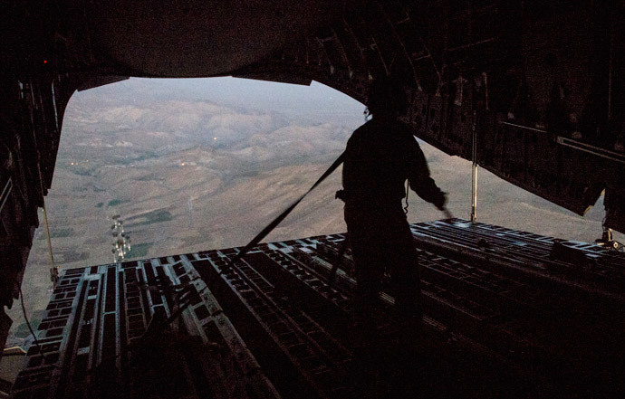 Tech. Sgt. Lynn Morelly, 816th Expeditionary Airlift Squadron, C-17 Globemaster III loadmaster, watches bundles of halal meals parachute to the ground during a humanitarian airdrop mission over Iraq in this August 9, 2014 photo (Reuters / Vernon Young Jr. / U.S. Air Force / Handout) 