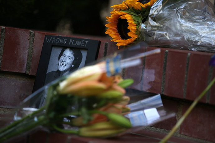 Flowers and pictures that are part of a growing memorial sit on the steps in front of the home where actor and comedian Robin Williams filmed the movie Mrs. Doubtfire on August 12, 2014 in San Francisco, California. (AFP Photo / Getty Images Justin Sullivan)