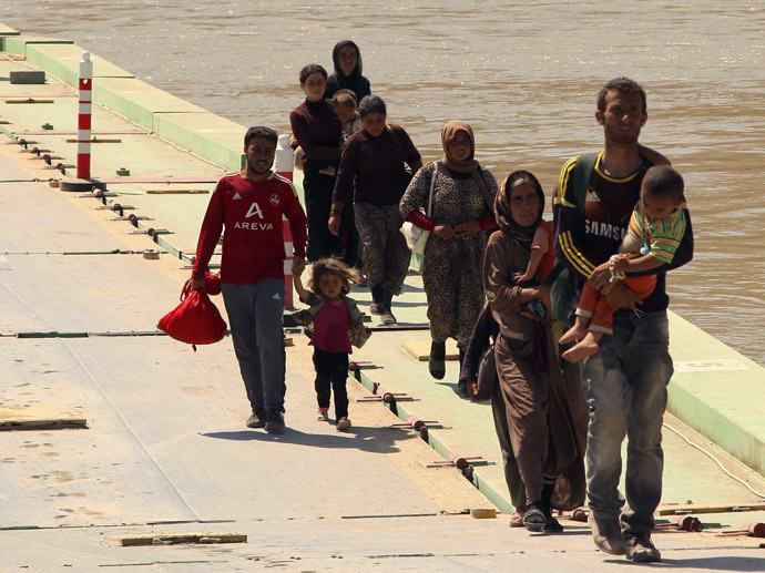 Displaced people from the minority Yazidi sect, fleeing the violence in the Iraqi town of Sinjar, re-enter Iraq from Syria at the Iraqi-Syrian border crossing in Fishkhabour, Dohuk province, August 13, 2014. (Reuters)