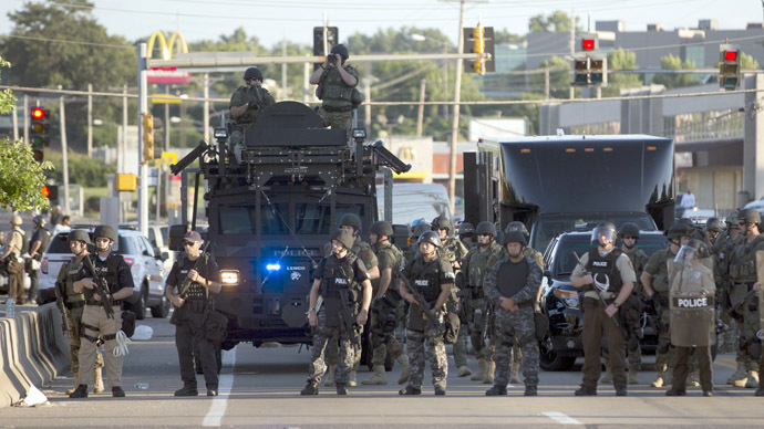 Police officers keep watch while demonstrators (not pictured) protest the death of black teenager Michael Brown in Ferguson, Missouri August 12, 2014. (Reuters)