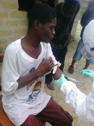 Health workers take blood from Barnie Sherrif, whose parents and sister succumbed to the deadly Ebola virus, in the village of Ballajah, Liberia. Barnie, 15, tested negative for the virus but is still shunned by his fellow villagers. (AFP/stringer)