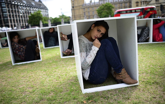 Volunteers sit in wooden boxes at Parliament Square, to represent living conditions in Gaza, during a protest in London August 14, 2014. (Reuters / Dylan Martinez)