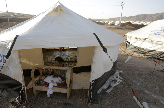 A woman from the minority Yazidi sect, who fled the violence in the Iraqi town of Sinjar, looks after her baby at Bajed Kadal refugee camp south west of Dohuk province August 15, 2014. (Reuters / Youssef Boudlal)