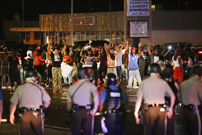 Demonstrators taunt police during a protest over the shooting death of Michael Williams on August 15, 2014 in Ferguson, Missouri, Police shot pepper spray, smoke, gas and flash grenades at protestors before retreating (AFP Photo / Scott Olson) 
