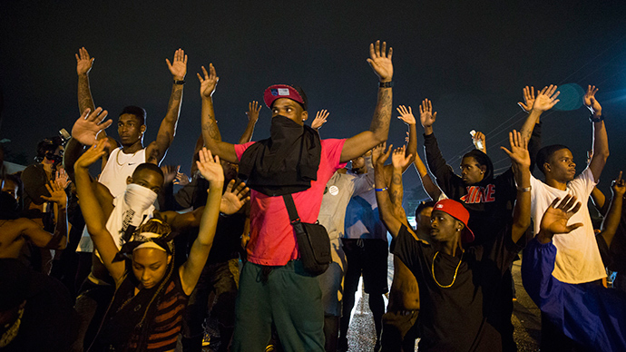 Demonstrators confront police with their arms raised during on-going demonstrations to protest against the shooting of Michael Brown, in Ferguson, Missouri, August 16, 2014 (Reuters / Lucas Jackson)