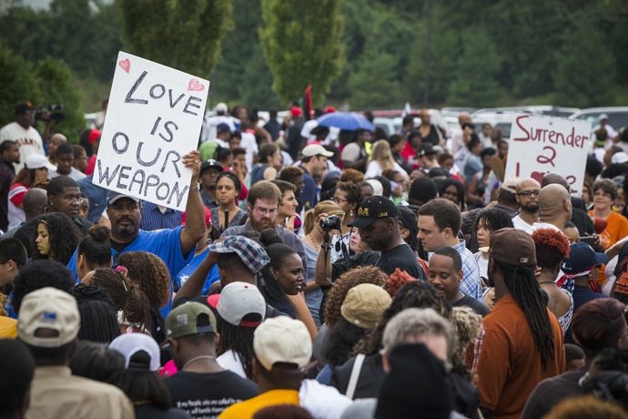 Demonstrators stand in an overflow crowd outside of a church where civil rights leader Al Sharpton spoke with community leaders, as communities continue to react to the shooting of Michael Brown, in Ferguson, Missouri August 17, 2014. (Reuters/Lucas Jackson)