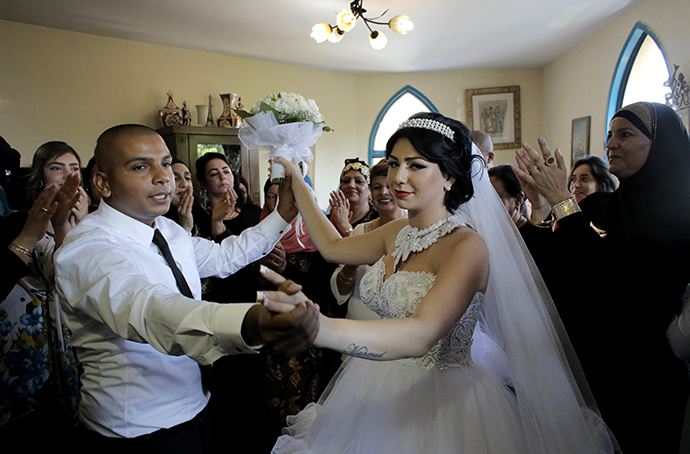 Groom Mahmoud Mansour, 26, and his bride Maral Malka, 23, celebrate with friends and family before their wedding in Mahmoud's family house in Jaffa, south of Tel Aviv August 17, 2014. (Reuters / Ammar Awad)
