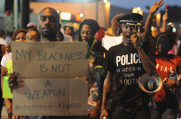 A demonstrator displays a sign during a protest in Ferguson, Missouri on August 18, 2014. (AFP Photo / Getty Images / Michael B. Thomas)