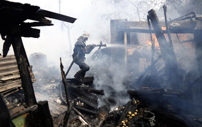 A firefighter extinguishes a fire in a suburb of Donetsk after a shelling on August 17, 2014. (AFP Photo / Max Vetrov)
