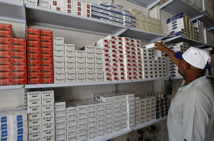 An Iraqi man takes a carton of cigarettes from a shop in Baghdad (AFP Photo / Sabah Arar)