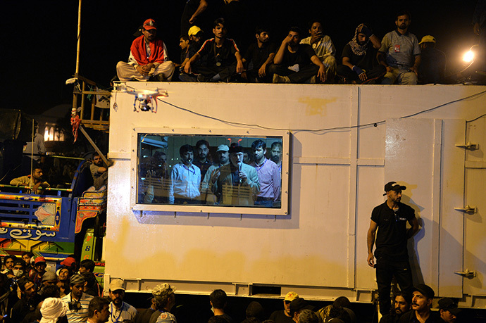 Canada-based preacher Tahir-ul-Qadri (2nd R-in window) addresses supporters from inside a shipping container in front of the parliament building during the "Revolution March" protest in Islamabad on August 20, 2014. (AFP Photo / Aamir Qureshi)