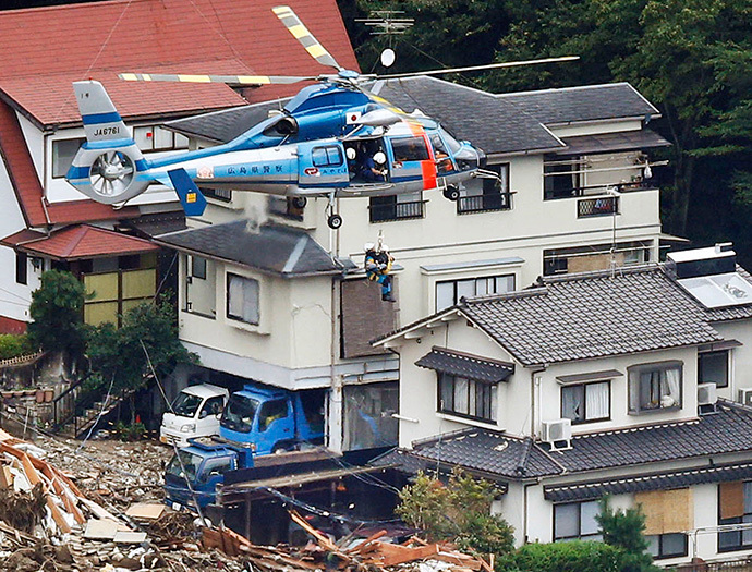 A local resident is lifted by a rescue helicopter from an area where a landslide swept through a residential area at Asaminami ward in Hiroshima, western Japan, in this photo taken by Kyodo August 20, 2014. (Reuters / Kyodo)