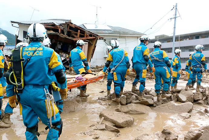 Rescue units of police officers walk during a rescue operation after a massive landslide swept through a residential area at Asaminami ward in Hiroshima, western Japan, in this photo taken by Kyodo August 20, 2014. (Reuters / Kyodo)