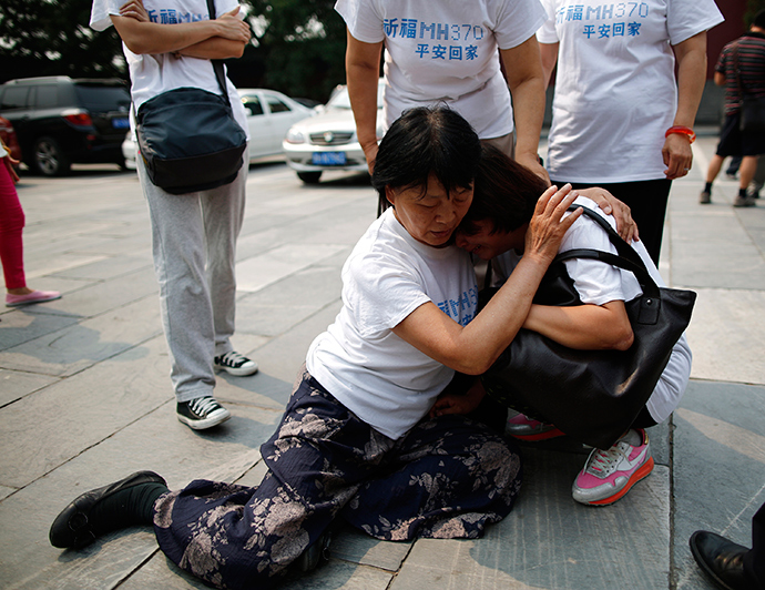 A family member of a passenger aboard the missing Malaysia Airlines flight MH370 comforts another relative as they gather to pray at Yonghegong Lama Temple in Beijing (Reuters / Kim Kyung-Hoon)