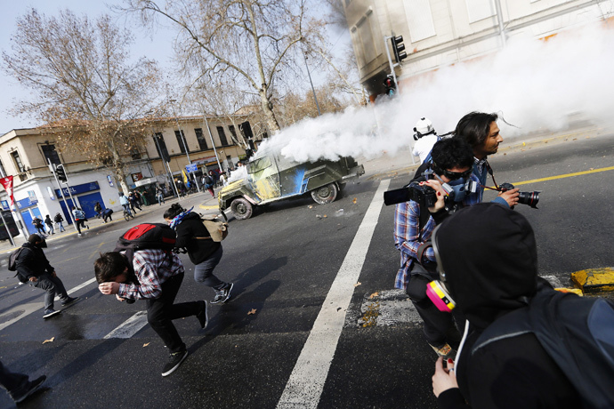A riot police vehicle releases tear gas during a demonstration against the government to demand changes in the education system in Santiago, August 21, 2014. (Reuters / Ivan Alvarado)