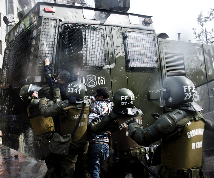Riot police arrest a teacher during a protest to demand to Chilean President Michelle Bachelet government to improve the public education quality in in Santiago, on August 21, 2014. (AFP Photo / Martin Bernetti) 