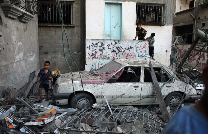 Palestinian children make their way through the rubble of a building destroyed following an Israeli military strike in Rafah in the south of the Gaza Strip on August 21, 2014. (AFP Photo / Said Khatib) 