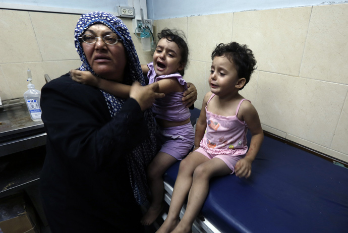  A Palestinian woman cares for wounded children at the hospital following an Israeli air strike on a house in Gaza City (AFP Photo / Mohammed Abed) 