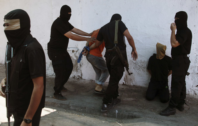 Hamas militants surround Palestinians suspected of collaborating with Israel before executing them in Gaza City August 22, 2014. (Reuters)