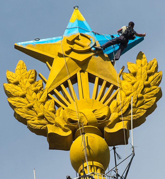 A worker paints the star on the spire of the Stalinist building at Kotelnicheskaya Embankment in Moscow that was painted blue by unidentified people (RIA Novosti / Ramil Sitdikov)
