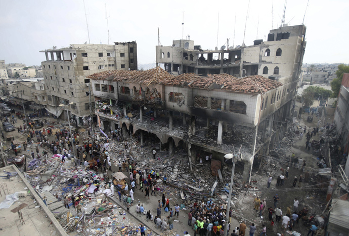 Palestinians gather around the remains of a commercial center, which witnesses said was hit by an Israeli air strike on Saturday, in Rafah in the southern Gaza Strip August 24, 2014. (Reuters / Ibraheem Abu Mustafa)