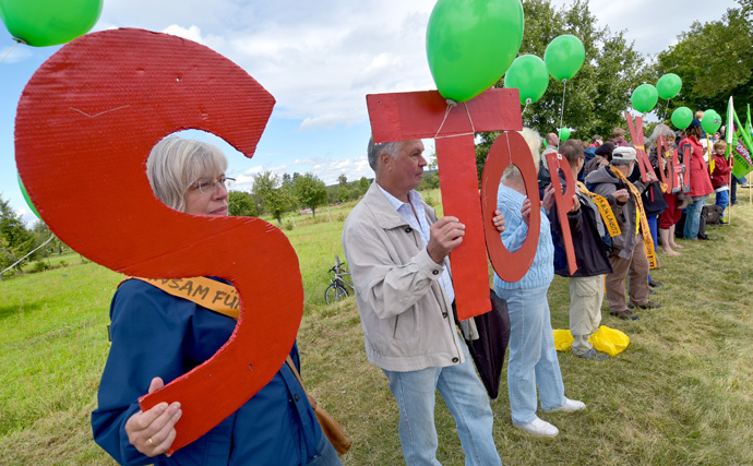 Protestors hold up letters forming "stop coal" (Stop Kohle) while forming a humain chain near the German-Polish border near Gross Gastrose on August 23, 2014. (AFP Photo / DPA / Patrick Pleul Germany out)
