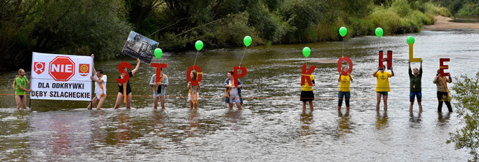 Protestors hold up letters forming "Stop Coal" (Stop Kohle) while form a humain chain in the German-Polish border river Neisse in Gross Gastrose on August 23, 2014. (AFP Photo / DPA / Patrick Pleul Germany out)